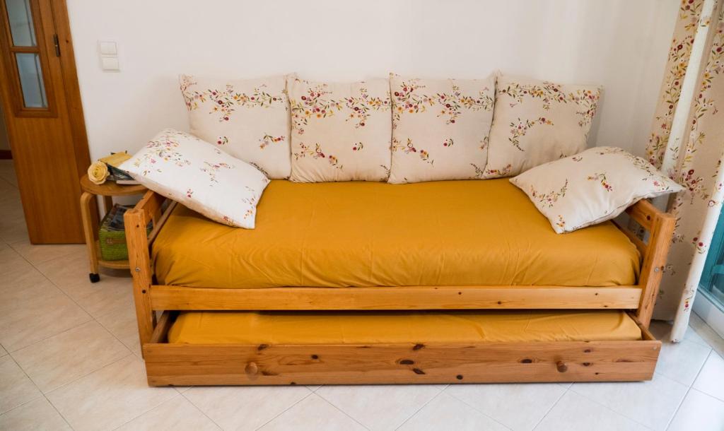 una cama de madera con 2 almohadas encima en Casa da Cerca Ferragudo Beach Caves Hiking Golf, en Ferragudo