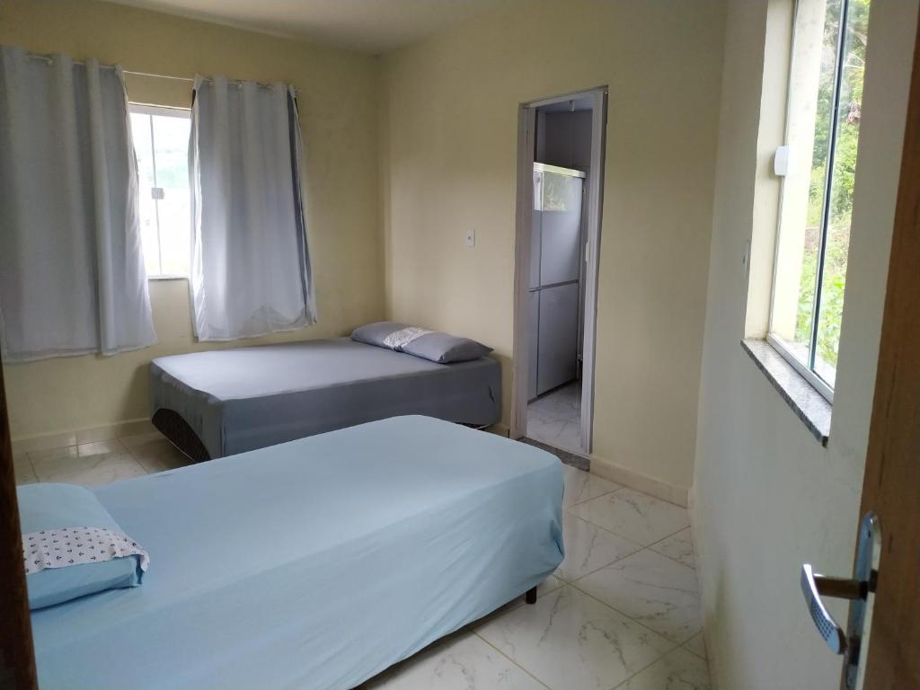 a bedroom with two beds and a window at RECANTO BUSCAPE in Alto Caparao