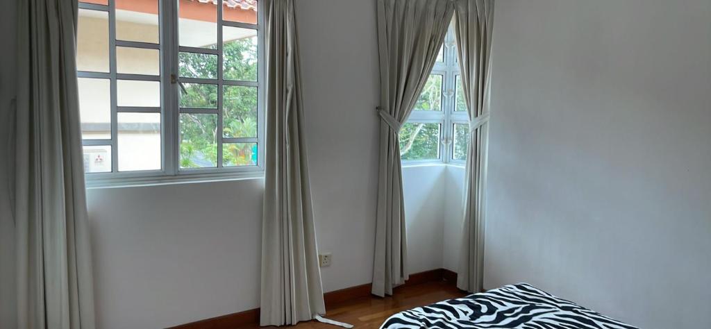 a room with two windows and a bed in front thereof at 花园别墅 in Singapore