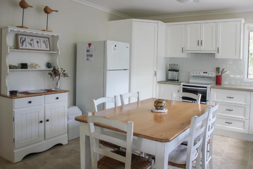 a kitchen with a wooden table and white cabinets at 2 51 Carlo Road Rainbow Beach in Rainbow Beach