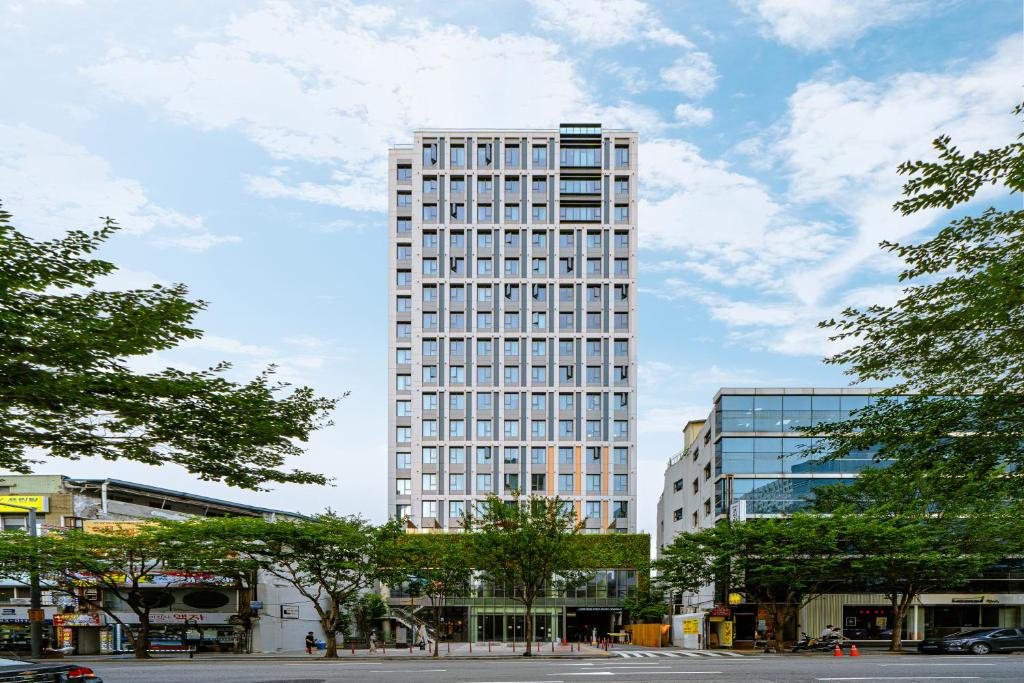 un edificio blanco alto con muchas ventanas en Urbanstay Myeongdong en Seúl