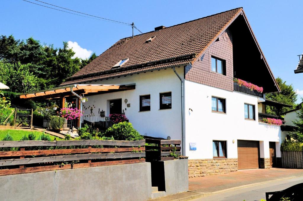 Casa blanca con techo marrón en Ferienwohnung Eudenbach, en Alsbach