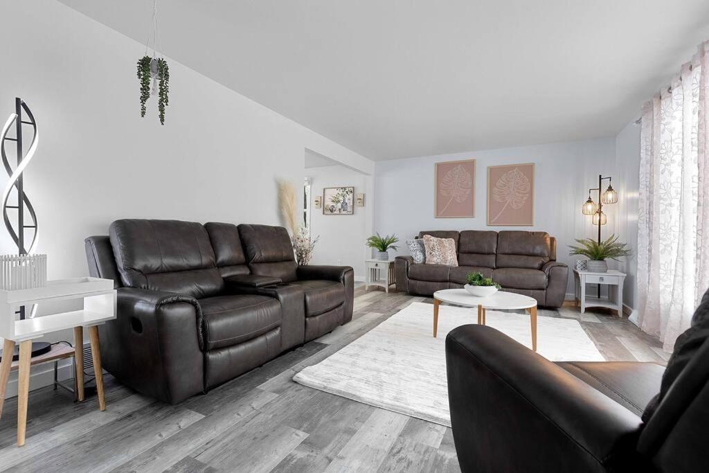 uma sala de estar com dois sofás de couro e uma mesa em The Meadows em Green Bay