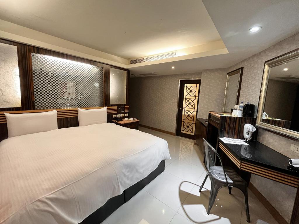 a bedroom with a bed and a desk and a computer at Guide Hotel Taipei Xinyi in Taipei