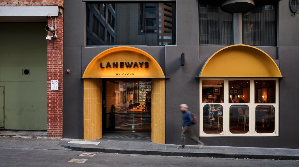 un hombre caminando delante de una tienda de abogados en Laneways by Ovolo en Melbourne