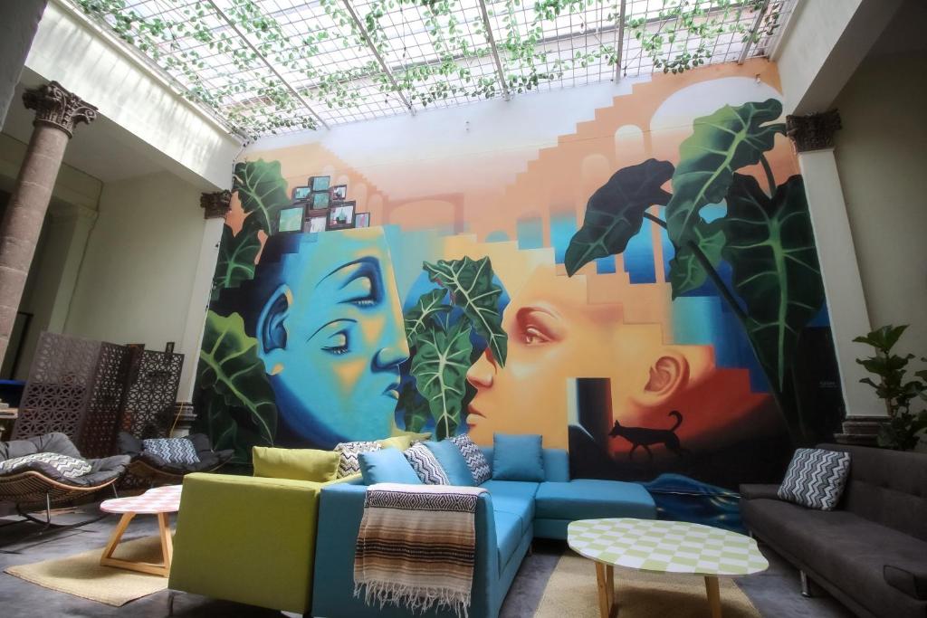 ein Wohnzimmer mit Wandgemälde in der Unterkunft Art House Hostel Guadalajara in Guadalajara