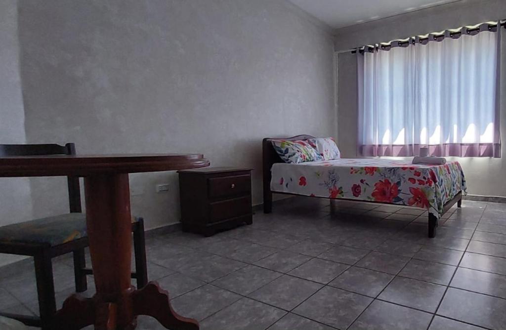 1 dormitorio con cama, mesa y ventana en Hotel Florio en Santa Cruz de la Sierra