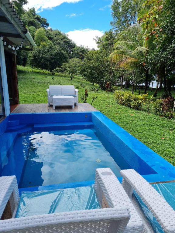 una piscina con sillas blancas y una piscina azul en Isla Cébaco, en Isla Cebaco 