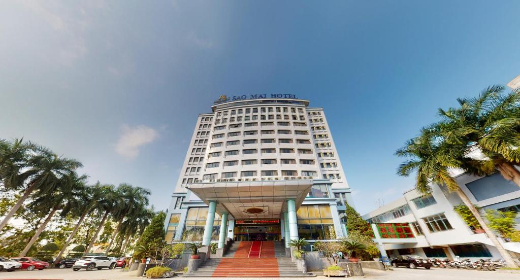 a tall white building with a staircase in front of it at Sao Mai Hotel in Thanh Hóa