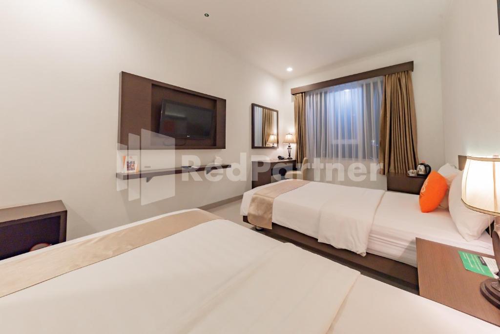 Postel nebo postele na pokoji v ubytování Hotel Alqueby near Kiara Artha Park Mitra RedDoorz