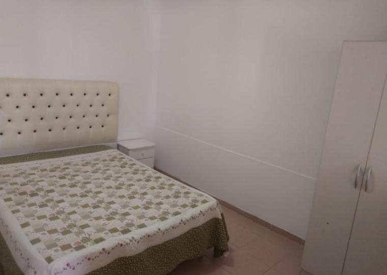 1 dormitorio con 1 cama en una habitación blanca en Alquiler de departamento por día excelente ubicacion en Neuquén