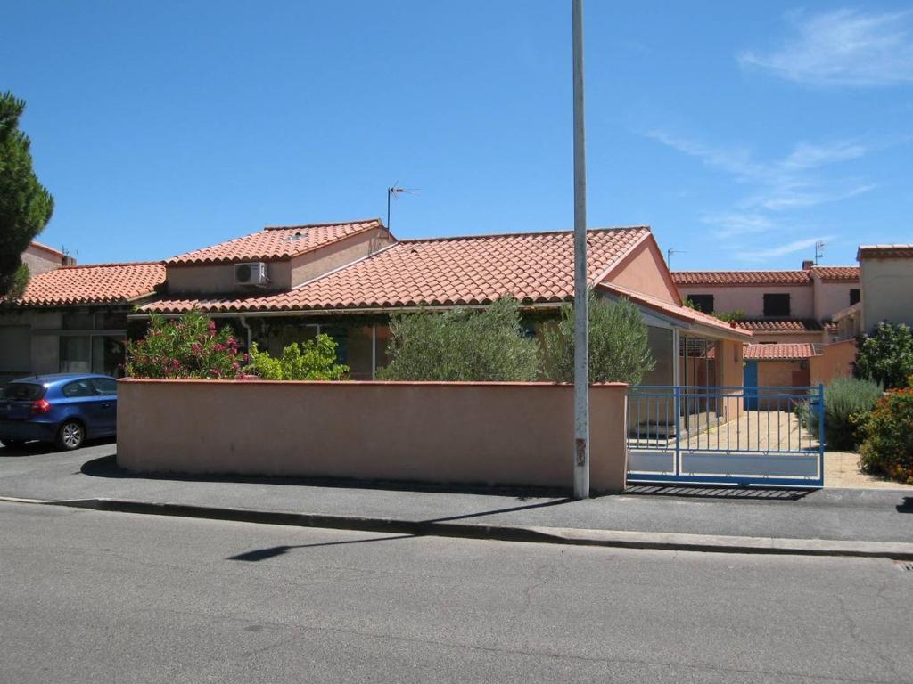 une maison avec une clôture en face d'une rue dans l'établissement Villa 4 pièces, 10 couchages, jardin, terrasses, à 900m de la plage, Saint-Cyprien - FR-1-106-35, à Saint-Cyprien