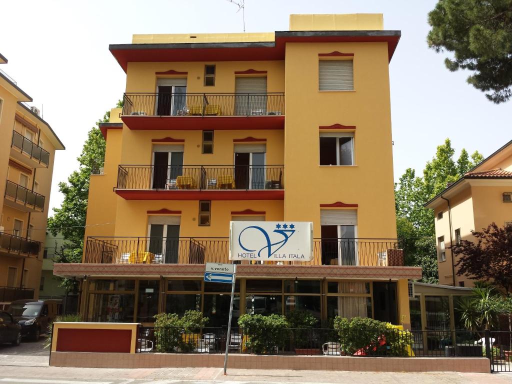 żółty budynek z znakiem przed nim w obiekcie Hotel Villa Itala w Rimini