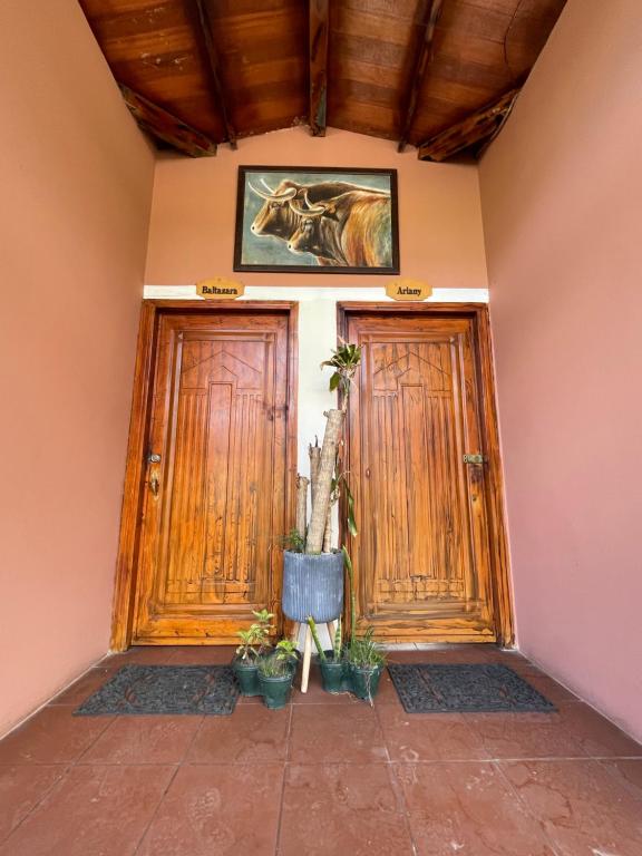 two doors of a house with a horse picture on the wall at Great location bed and breakfast in Latacunga