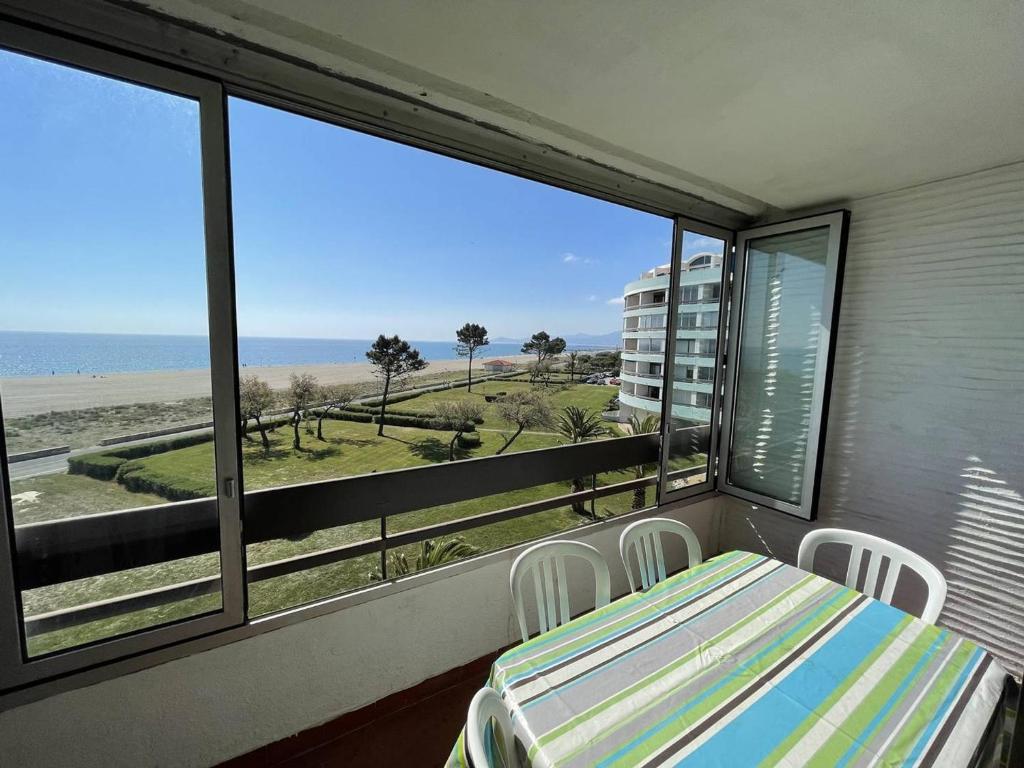 un balcon avec une table et des chaises et une vue sur la plage dans l'établissement Appartement T2 avec 6 couchages, animaux admis, parking, wifi - FR-1-106-75, à Saint-Cyprien