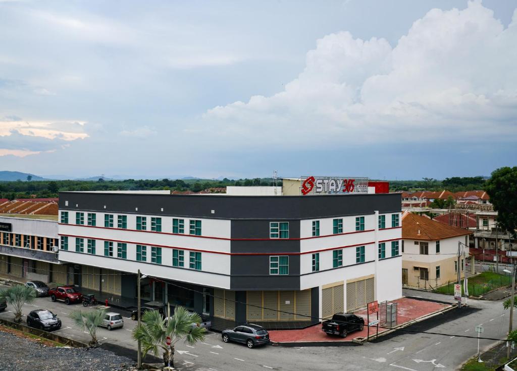 a large white building with a black roof at STAY 365 HOTEL in Changlun