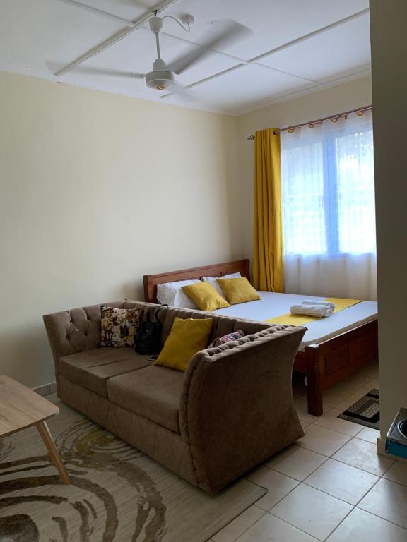 a living room with a couch and a bed at Kendy’s Cozy Haven in Mombasa