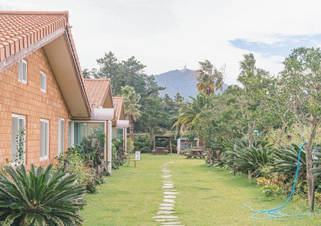 a yard next to a house with a hose at Jeju Healing Resort in Jeju