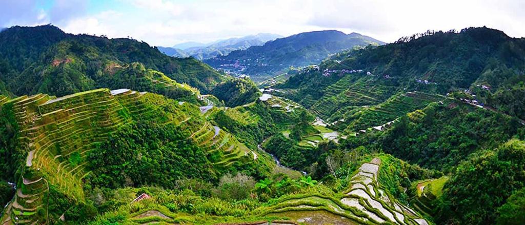 een uitzicht op een vallei met bergen en bomen bij Rita's Homestay in Talap