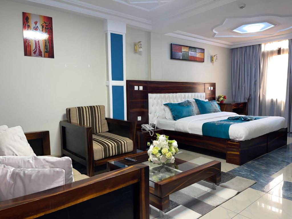 een slaapkamer met een bed en een woonkamer bij Hotel Le Kremlin Yaoundé in Yaoundé