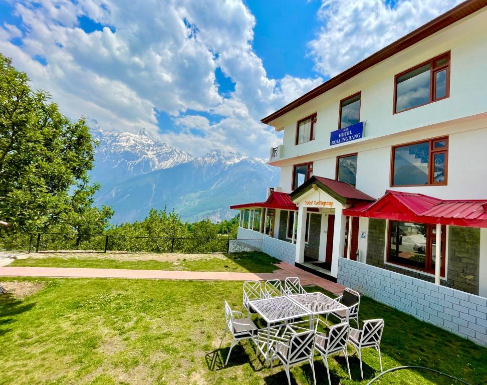 a patio with a table and chairs in front of a building at Hotel Rollingrang in Kalpa