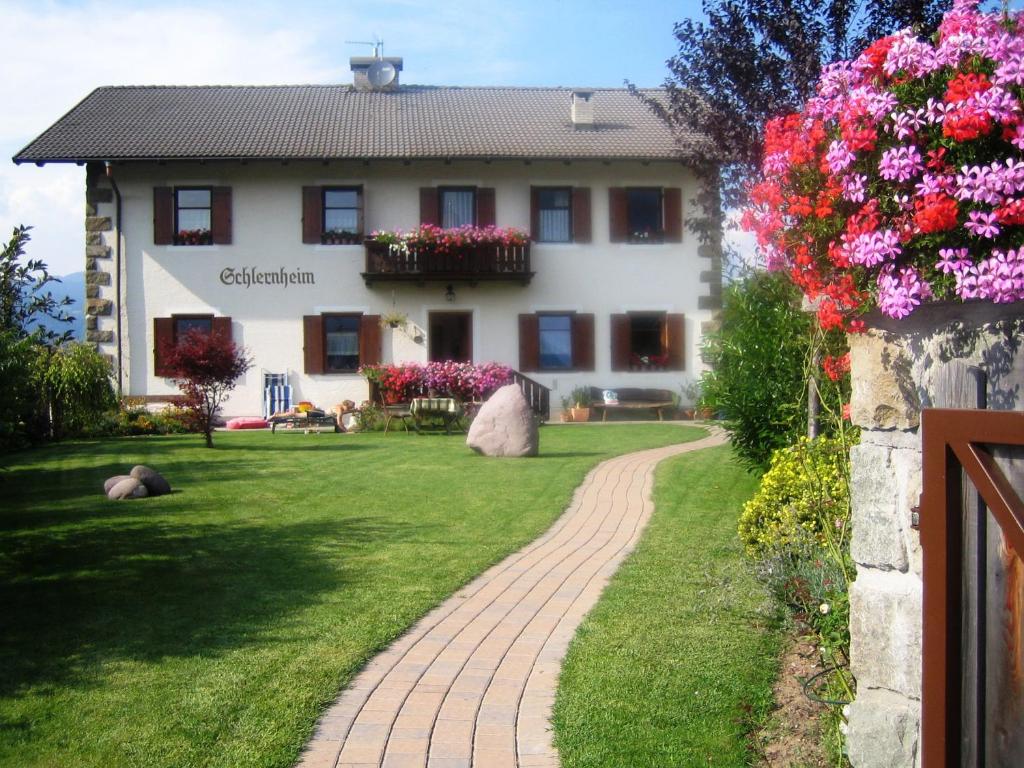 a house with a path in front of a yard at Schlernheim Apartment in Völs am Schlern