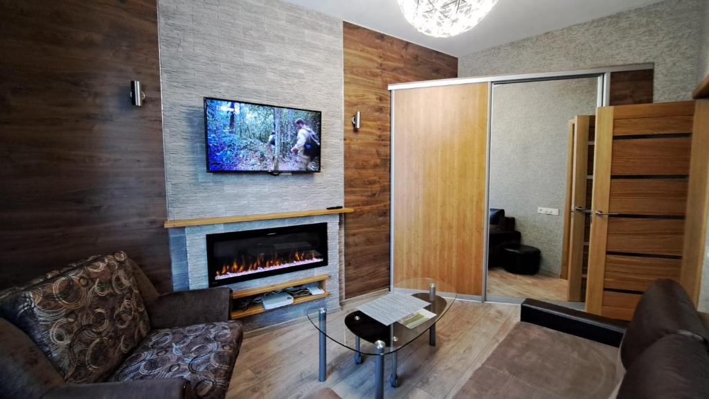 a living room with a fireplace and a tv on a wall at Rigas 72 in Daugavpils