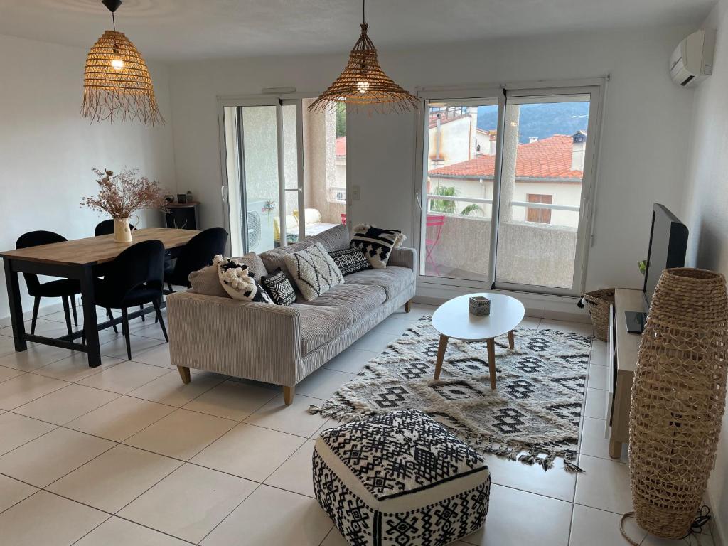 a living room with a couch and a table at Appartement T3 climatisé,balcon in Le Boulou