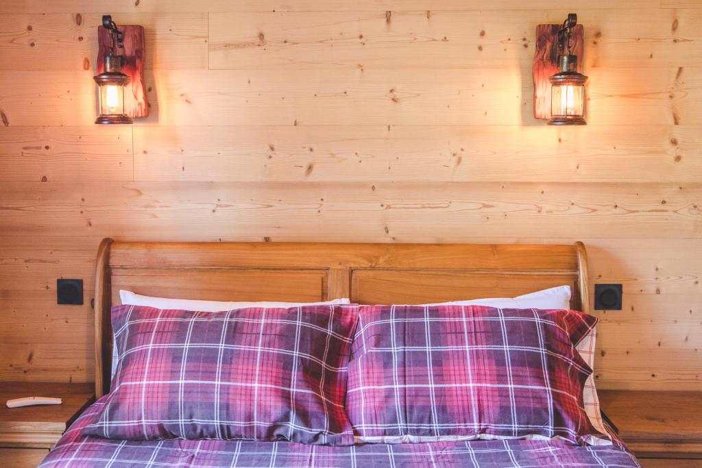 a bed with two pillows and two lights on the wall at La Masia Del Taulat Chambres d´Hôtes in Llo