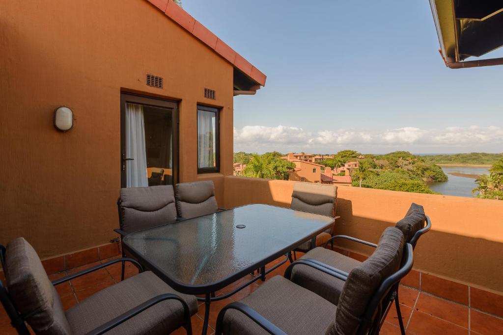 a table and chairs on a balcony with a view of a river at San Lameer Villa 2015 - 3 Bedroom Standard - 6 pax - San Lameer Rental Agency in Southbroom