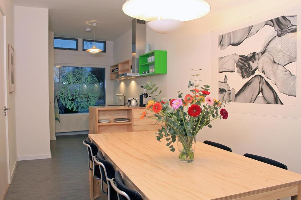 a kitchen with a table with a vase of flowers on it at B&B Central Park in Utrecht
