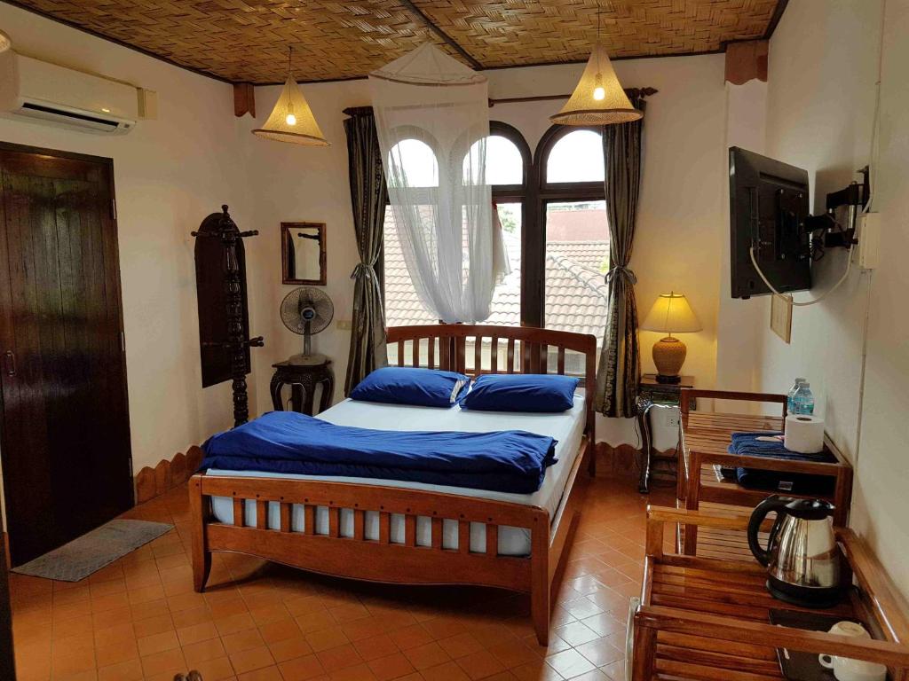 1 dormitorio con 1 cama, TV y ventana en Mut Mee Garden Guest House en Nong Khai