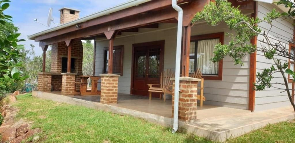 a small house with a porch and a patio at Kiepersol Cottages - Cottage A in East London