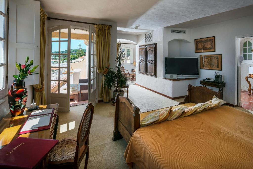 a bedroom with a large bed and a television at Hotel Le Maquis in Porticcio