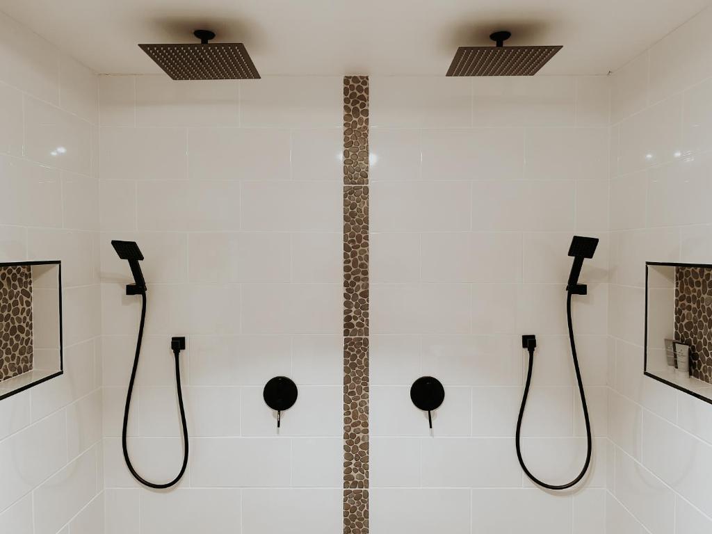 a wall with three shower fixtures on a wall at Misty Mountain Retreat in Olinda