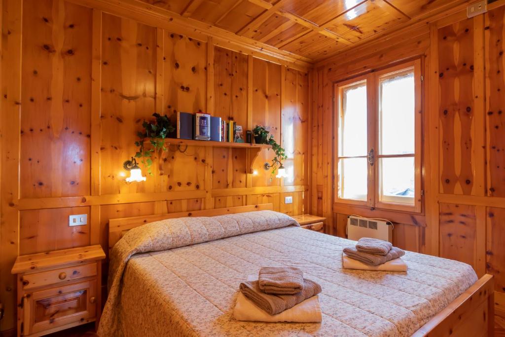 a bedroom with a bed in a wooden room at New apartment in Bormio - Centrale 20 in Piatta