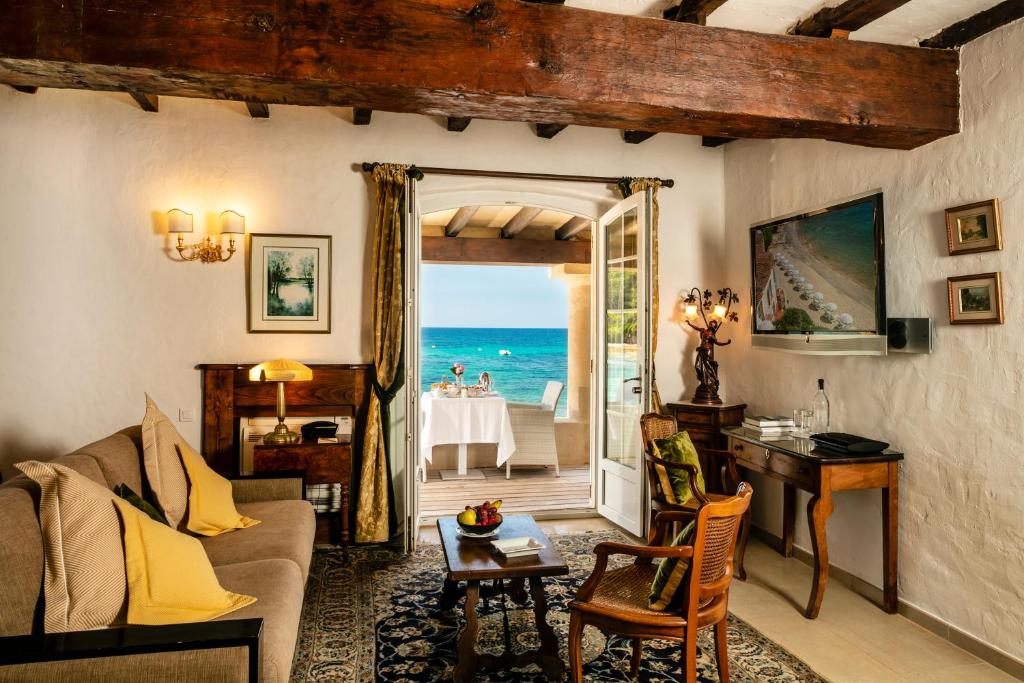 a living room with a view of the ocean at Hotel Le Maquis in Porticcio
