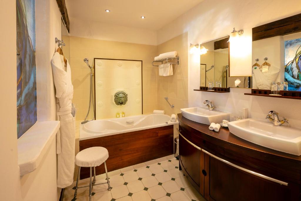 a bathroom with two sinks and a bath tub and a tub at Hotel Le Maquis in Porticcio