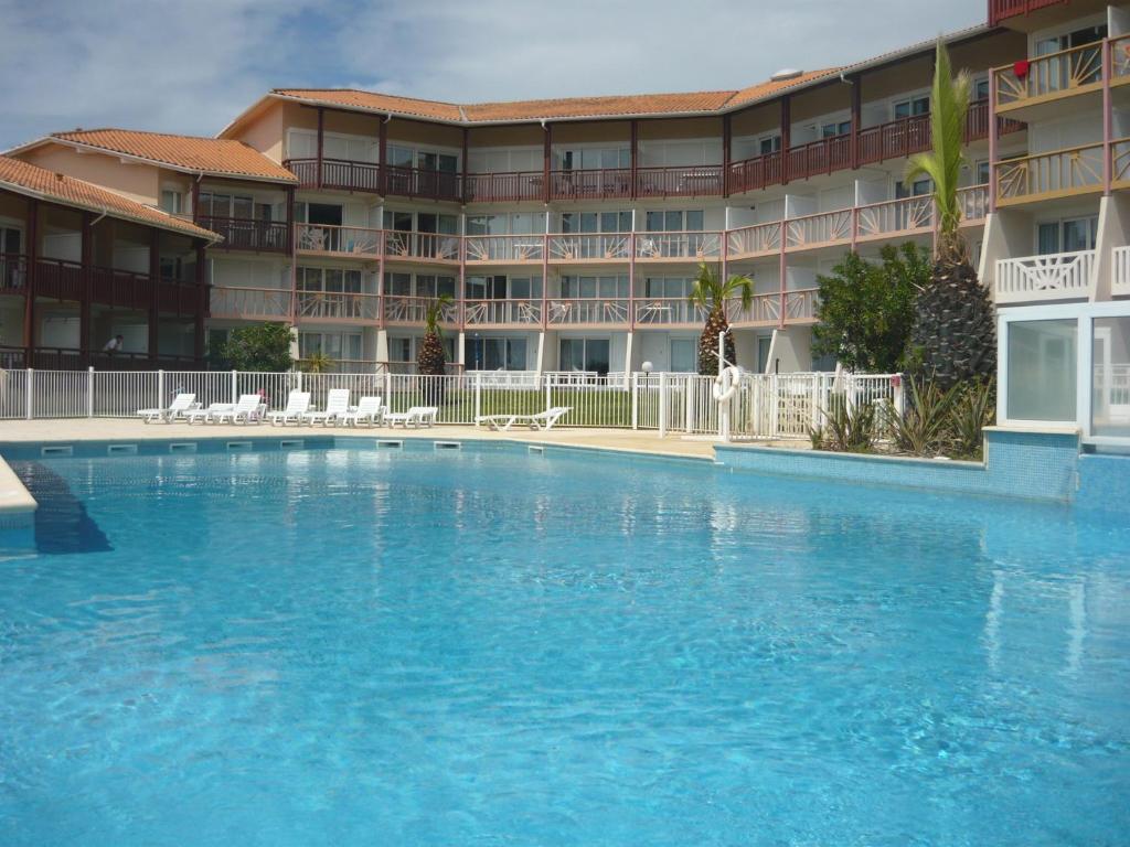 une grande piscine en face d'un hôtel dans l'établissement Appartements à côté Lac Marin de Port d'Albret, à Vieux-Boucau-les-Bains