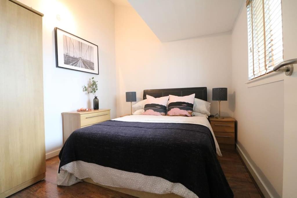 利物浦的住宿－Lovely Modern Central & Spacious，一间卧室配有一张带黑色毯子的床