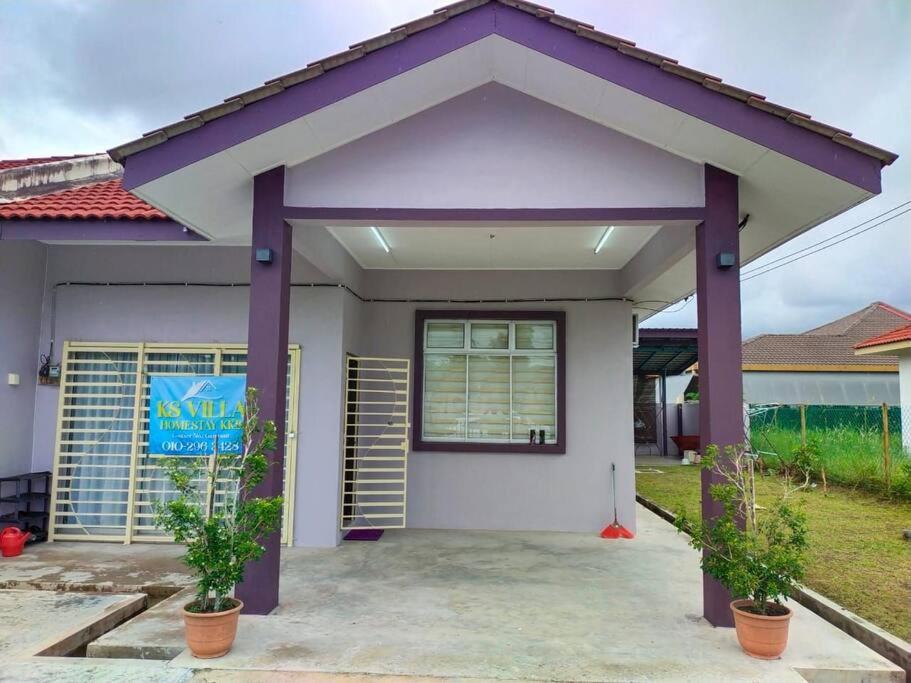 una pequeña casa con techo púrpura en KS Villa Homestay KKB, en Kampong Peruntun