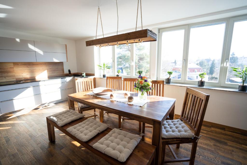 uma cozinha com uma mesa de madeira e 2 cadeiras em Hochwertiges Apartment / 120m² / Dachterrasse / Parking em Dresden