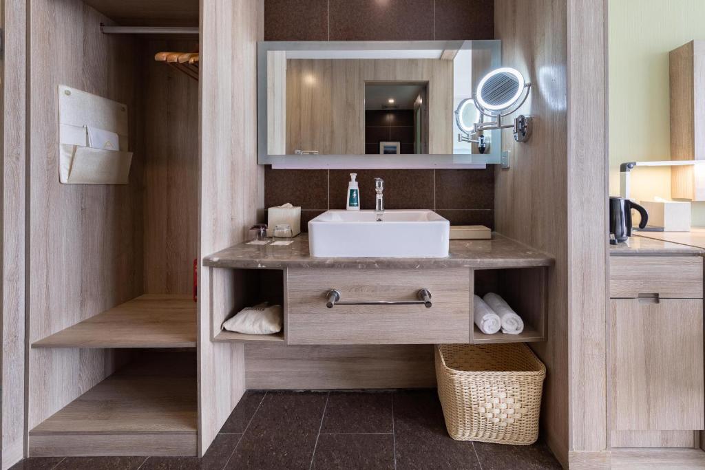 uma casa de banho com um lavatório e um espelho em Atour Hotel Jinan High-tech Wanda Plaza Tiancheng Road em Jinan