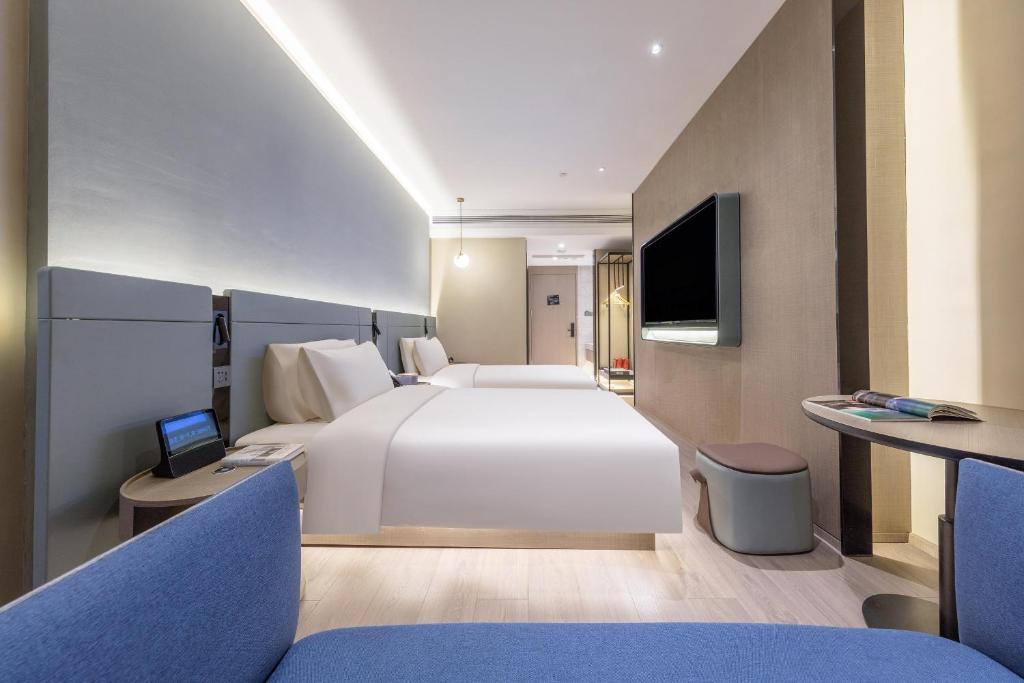 Habitación de hotel con cama grande y TV en Atour S Hotel Tianjin Binjiang Road Hanglung Plaza, en Tianjin