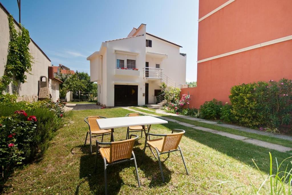 ein Tisch und Stühle im Hof eines Hauses in der Unterkunft Garden apartment in Baška