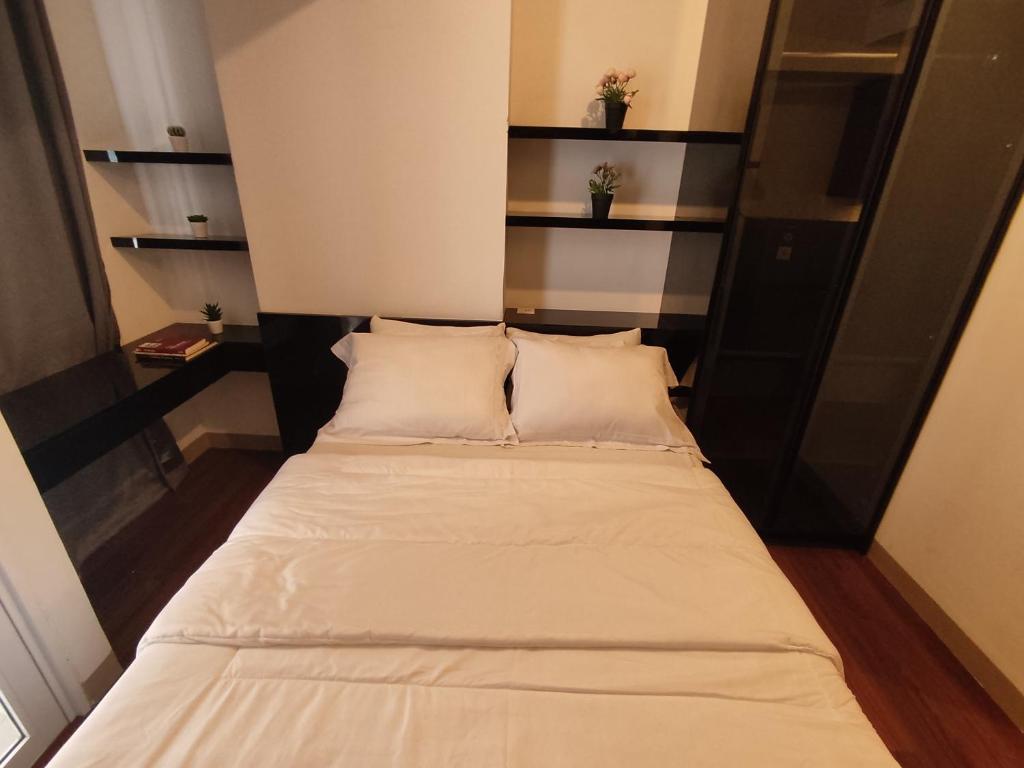 a bed with two pillows in a small room at Apartemen Tokyo Riverside @pik 2 Tower Dotonbori Lt 15 