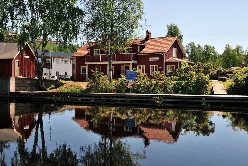 ein Haus neben einem Wasserkörper in der Unterkunft Hotell Hemgården in Bengtsfors