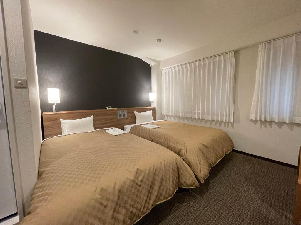 Postel nebo postele na pokoji v ubytování Kusatsu Daiichi Hotel