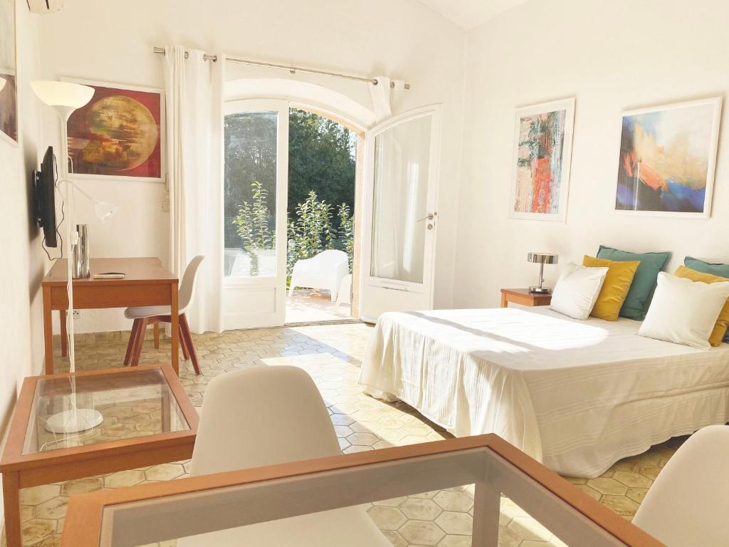 um quarto com uma cama, uma mesa e cadeiras em Studio 17 - LES SUITES DE ROBINSON - Résidence avec piscine en bord de Siagne, à Mandelieu-La-Napoule em Mandelieu-la-Napoule