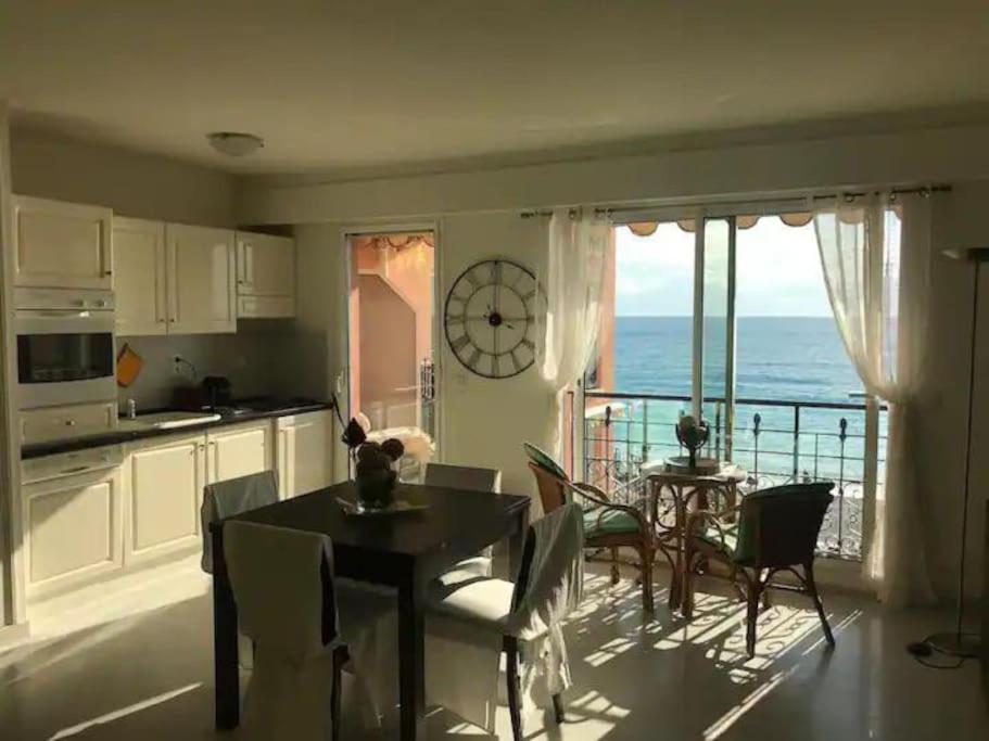 een keuken en eetkamer met uitzicht op de oceaan bij Victoria bilocale centro città e vista mare in Menton